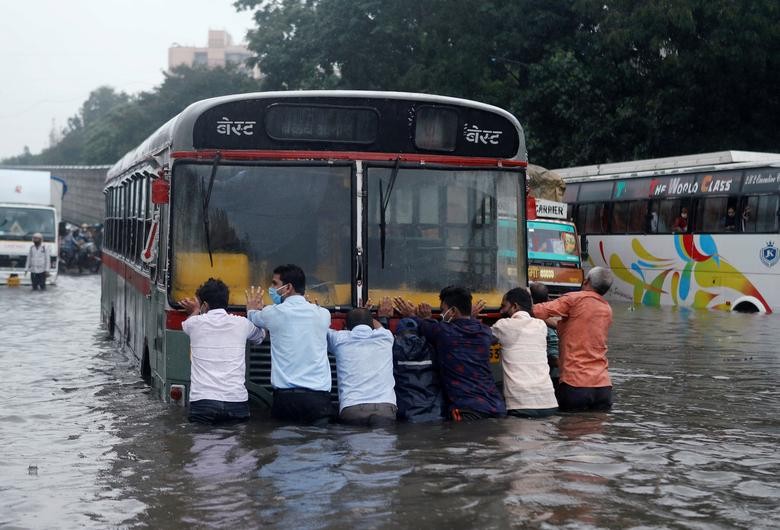 People push a bus through a waterlogged road after heavy rainfall in Mumbai, India. REUTERS/Francis Mascarenhas    